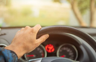 Sürücünün elleri direksiyonda ve gösterge panelinde.