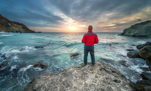 Hombre Orilla Del Mar Pie Sobre Piedra Mirando Puesta Sol —  Fotos de Stock