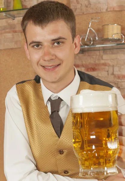 Waiter holds glass of beer — Stock Photo, Image