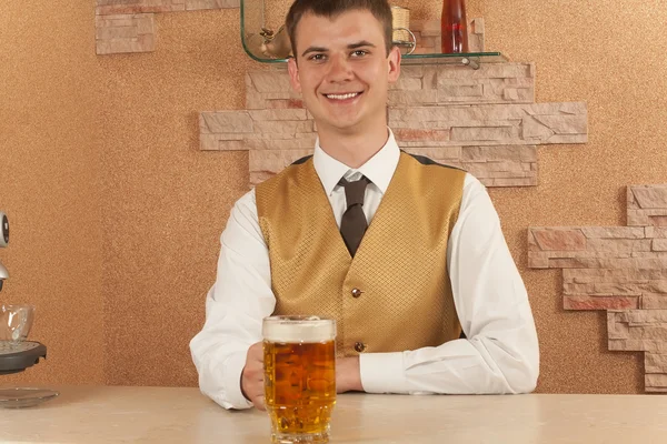 Kelner trzyma szklankę piwa — Zdjęcie stockowe