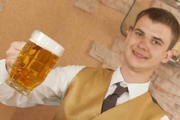 Waiter holds glass of beer — Stock Photo, Image