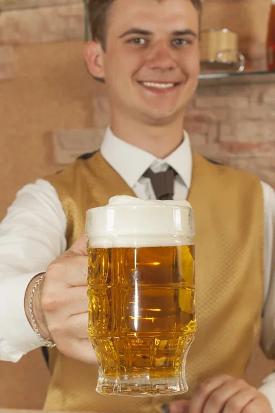 Waiter holds glass of beer — Stock Photo, Image