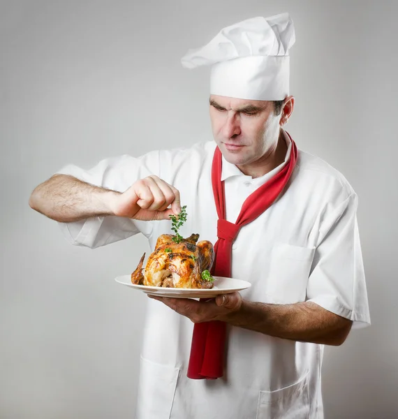 Chef holding plate with roasted chicken — Stock Photo, Image