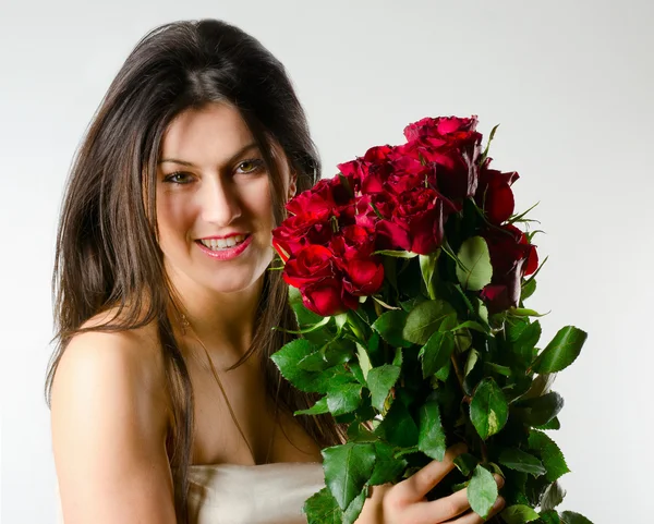 Όμορφη γυναίκα με κόκκινα τριαντάφυλλα — Φωτογραφία Αρχείου