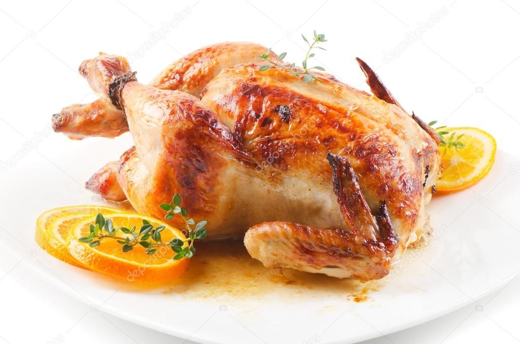 Roasted chicken on white plate with orange