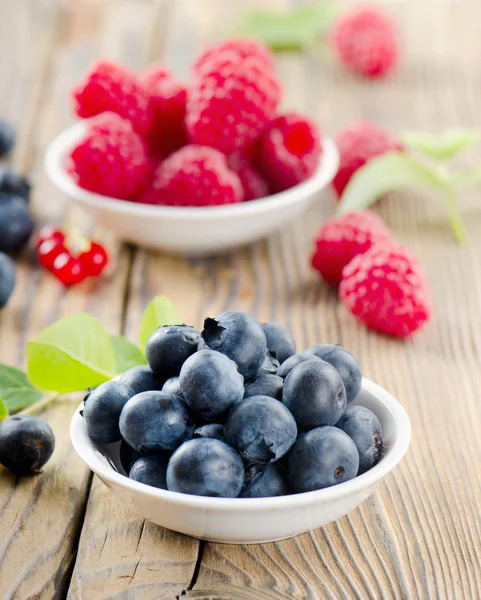 Bleuets et framboises sur table en bois — Photo