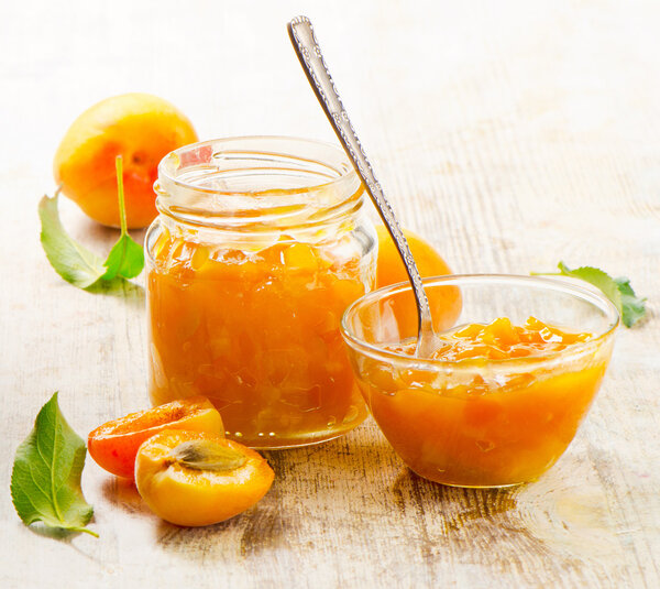 Apricots jam on a wooden table.