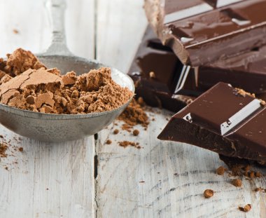kakao tozu ve kırılmış çikolata bar ve ahşap bir masa üzerinde