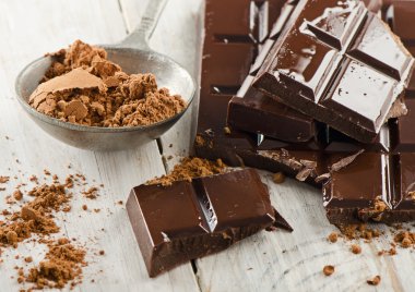 kakao tozu ve kırılmış çikolata bar ve ahşap bir masa üzerinde