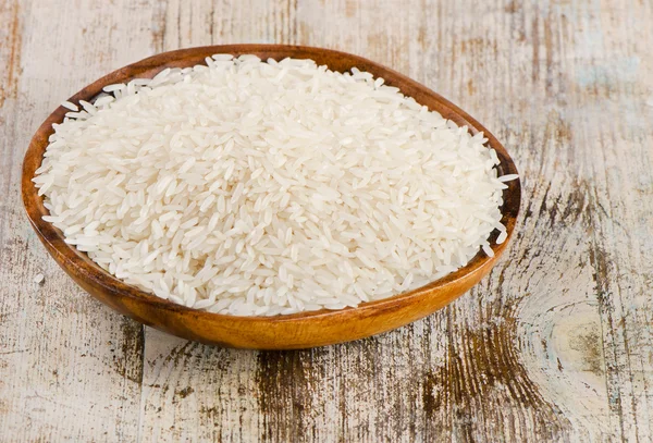 Reis in Schüssel auf einem Holztisch — Stockfoto