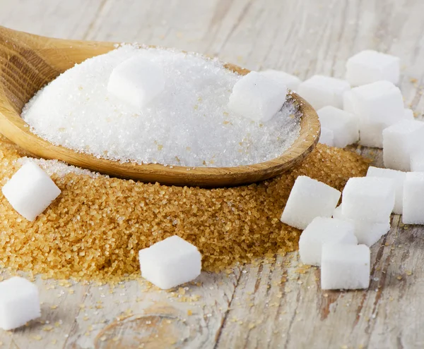 Sugar on wooden table — Stock Photo, Image