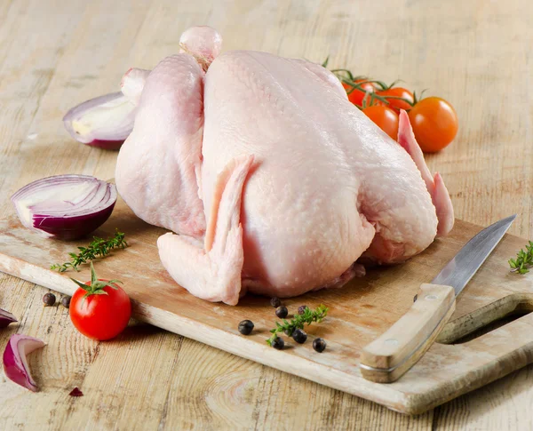 Pollo crudo intero su un tavolo di legno — Foto Stock