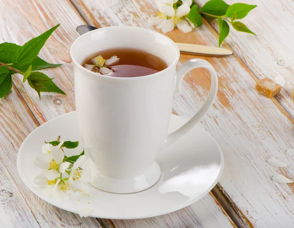 Tè in una tazza bianca con fiori — Foto Stock