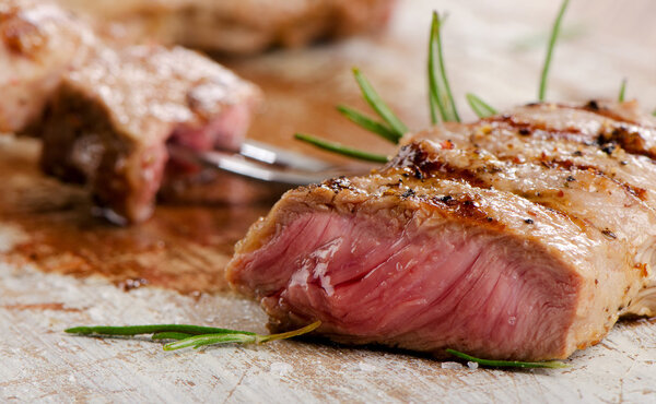 Beef steak on a wooden table. Selective focus