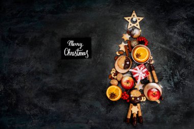 Karanlık arka planda yiyecekten yapılmış Noel ağacı. Kutlama kompozisyonu. Üst görünüm, alanı kopyala