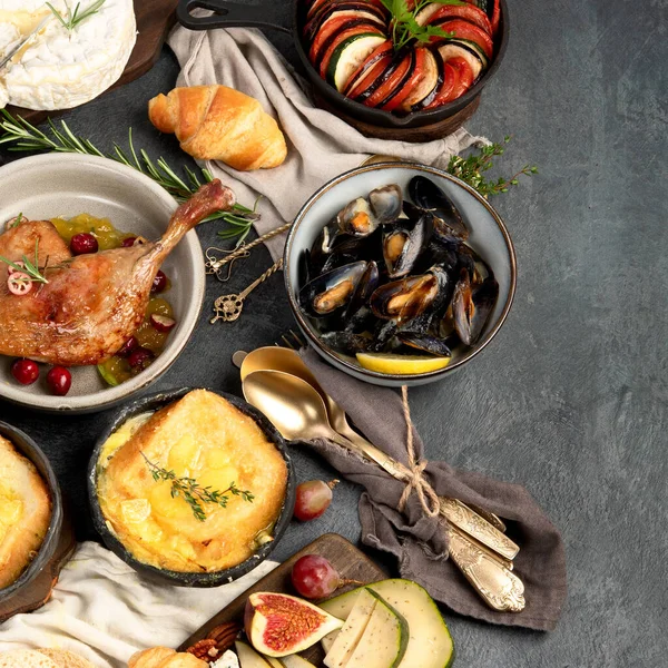 French food assortment on dark background. Traditional cuisine concept. Top view, flat lay, copy space