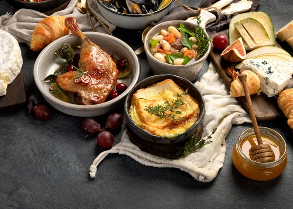 French food assortment on dark background. Traditional cuisine concept.