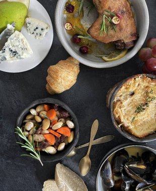 Fransız yemekleri ve aperatifler koyu arka planda servis ediliyor. Geleneksel gıda konsepti. Üst görünüm, düz görünüm, kopyalama alanı