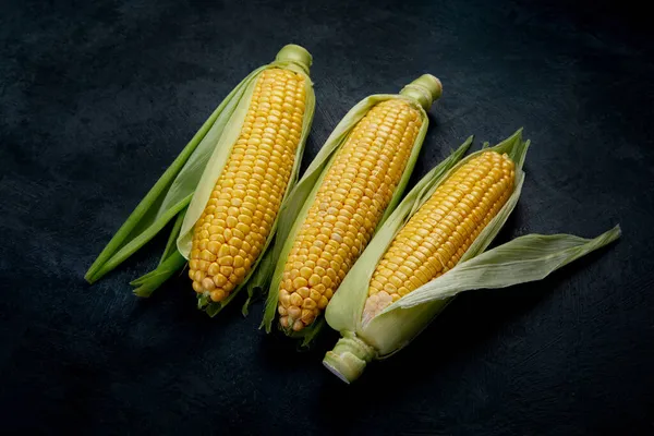 暗い背景に生のトウモロコシやトウモロコシ 収穫食品の概念 — ストック写真