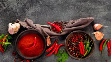 Kırmızı biber ya da kırmızı biber koyu arkaplanda da biber. Geleneksel baharat konsepti. Üst görünüm, düz görünüm, kopyalama alanı