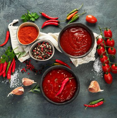 Gri arka planda baharatlı acı biberli domates sosu. Geleneksel acı sos konsepti. 