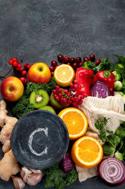 Koyu arka planda C vitamini içeren yiyecekler. Sağlıklı beslenme konsepti. Üst görünüm, düz görünüm, kopyalama alanı
