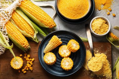 Mısır koçanları ve mısır homurdanmaları gri arka planda. Yemek konseptini hasat et. Üst manzara, düz uzanma