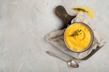 Gri arka planda mısır lapası. Sağlıklı gıda konsepti. Üst görünüm düzlüğü, boşluk kopyala