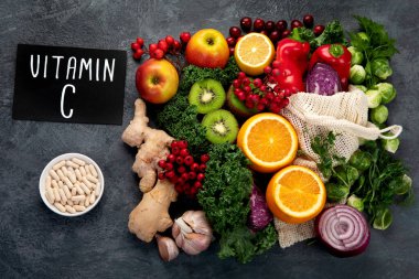 Koyu arka planda C vitamini içeren yiyecekler. Sağlıklı beslenme konsepti. Üst görünüm, düz görünüm, kopyalama alanı