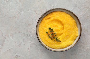 Gri arka planda mısır lapası. Sağlıklı gıda konsepti. Boşluğu kopyala
