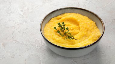 Gri arka planda mısır lapası. Sağlıklı gıda konsepti. Boşluğu kopyala