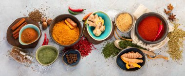 Gri arka planda çeşitli Hint baharatları. Geleneksel baharat konsepti. Üst manzara, düz yatış, manzara