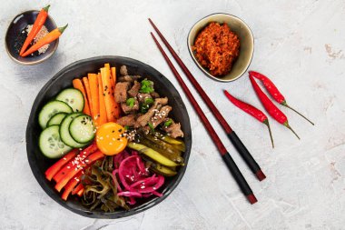 Gri arka planda aperatifleri olan bir bibimbap. Geleneksel Kore yemekleri. Üst görünüm, düz görünüm, kopyalama alanı