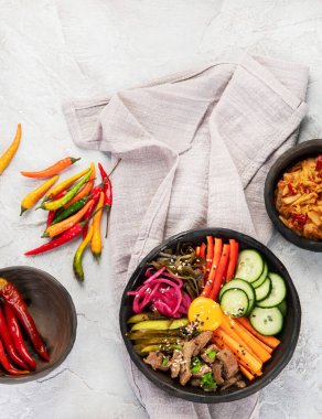 Gri arka planda aperatifleri olan bir bibimbap. Geleneksel Kore yemekleri. Üst görünüm, düz görünüm, kopyalama alanı