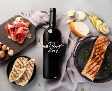 Pinot Noir gri arka planda. Geleneksel alkol içecekleri. Kırmızı şarap çeşidi. Üst manzara, düz uzanma