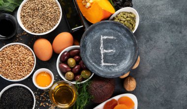 Koyu arka planda yüksek E vitamini içeren yiyecekler. Sağlıklı beslenme konsepti. Üst görünüm, düz görünüm, kopyalama alanı
