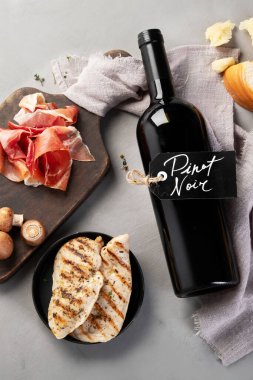 Pinot Noir gri arka planda. Geleneksel alkol içecekleri. Kırmızı şarap çeşidi. Üst görünüm, düz görünüm, kopyalama alanı