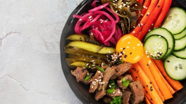 Gri arka planda aperatifleri olan bir bibimbap. Geleneksel Kore yemekleri. Üst görünüm, düz görünüm, kopyalama alanı
