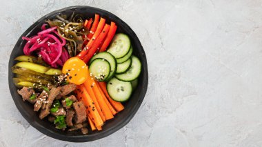 Gri arka planda aperatifleri olan bir bibimbap. Geleneksel Kore yemekleri. Üst görünüm, düz görünüm, kopyalama alanı