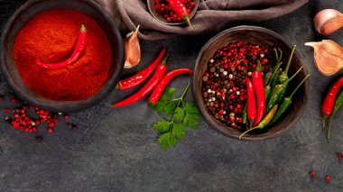 Kırmızı biber ya da kırmızı biber koyu arkaplanda da biber. Geleneksel baharat konsepti. Üst görünüm, düz görünüm, kopyalama alanı