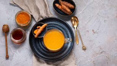 Açık gri arka planda sağlıklı zerdeçal altın çayı. Geleneksel Hint içkisi. Üst görünüm, düz görünüm, kopyalama alanı