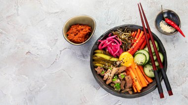 Gri arka planda aperatifleri olan bir bibimbap. Geleneksel Kore yemekleri. Üst görünüm, düz görünüm, kopyalama alanı