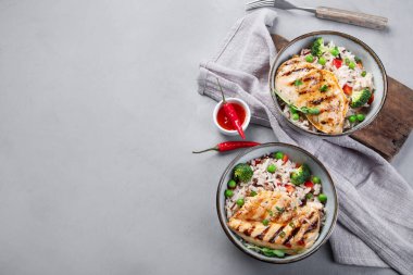 Sebzeli ızgara tavuk ve gri arka planda pilav. Sağlıklı beslenme konsepti. Üst görünüm, düz görünüm, kopyalama alanı