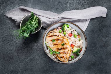 Sebzeli ızgara tavuk ve gri arka planda pilav. Sağlıklı beslenme konsepti. Üst görünüm, düz görünüm, kopyalama alanı