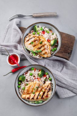 Sebzeli ızgara tavuk ve gri arka planda pilav. Sağlıklı beslenme konsepti. Üst görünüm, düz görünüm, kopyalama alanı