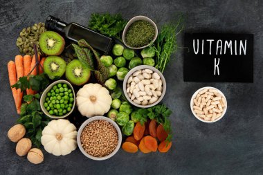 Koyu arka planda yüksek K vitamini içeren yiyecekler. Sağlıklı beslenme konsepti. Üst görünüm, düz görünüm, kopyalama alanı