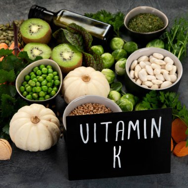 Koyu arka planda yüksek K vitamini içeren yiyecekler. Sağlıklı diyet kavramı. 