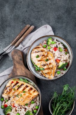 Sebzeli ızgara tavuk ve gri arka planda pilav. Sağlıklı beslenme konsepti. Üst görünüm, düz görünüm, kopyalama alanı