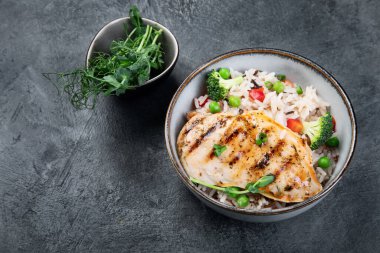 Sebzeli ızgara tavuk ve gri arka planda pilav. Sağlıklı beslenme konsepti. Boşluğu kopyala