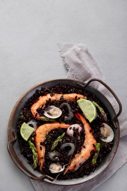 Gri arka planda siyah deniz ürünleri pastası. Akdeniz diyeti. Geleneksel gıda konsepti. Düz konum, üst görünüm, kopyalama alanı